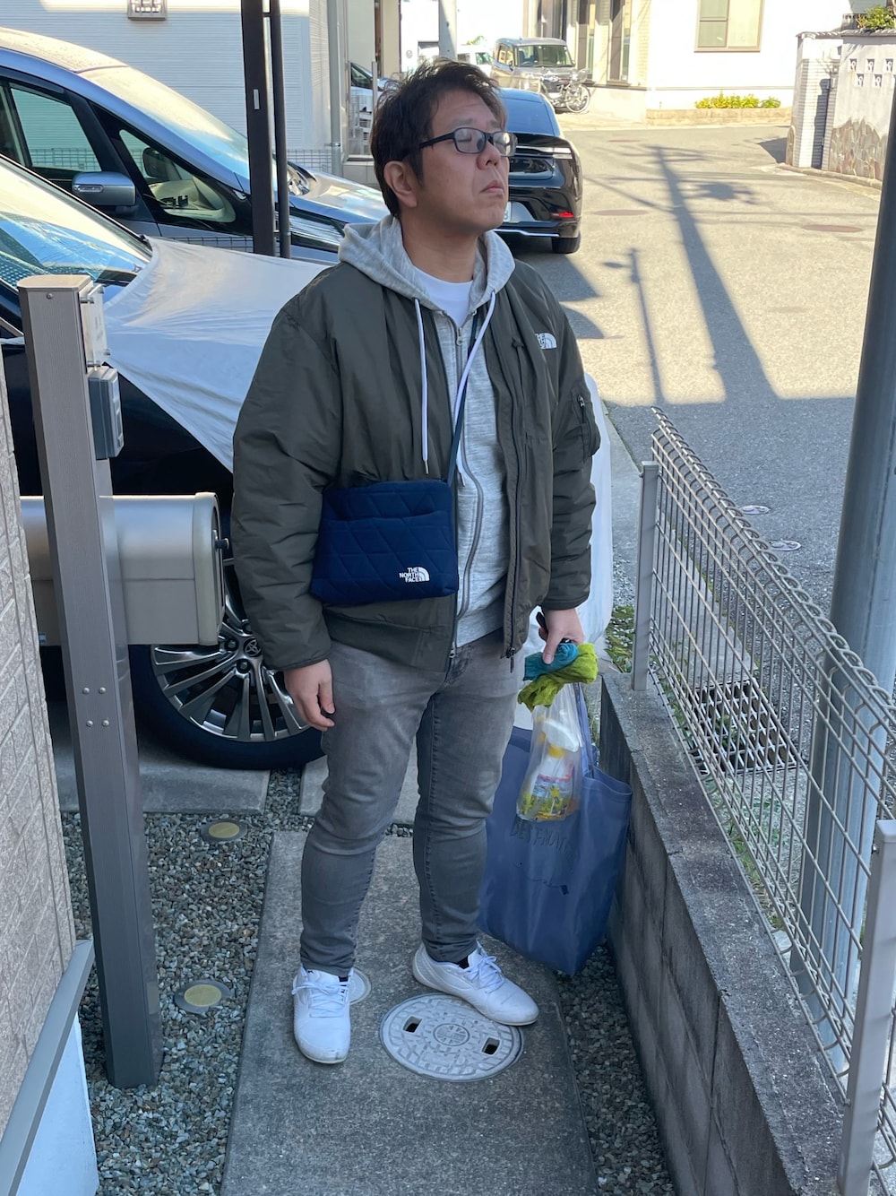 グレー系のデニムパンツ、ホワイト系のシューズ、グリーン系のMA-1を着用したメンズの冬コーディネートの1枚目の写真