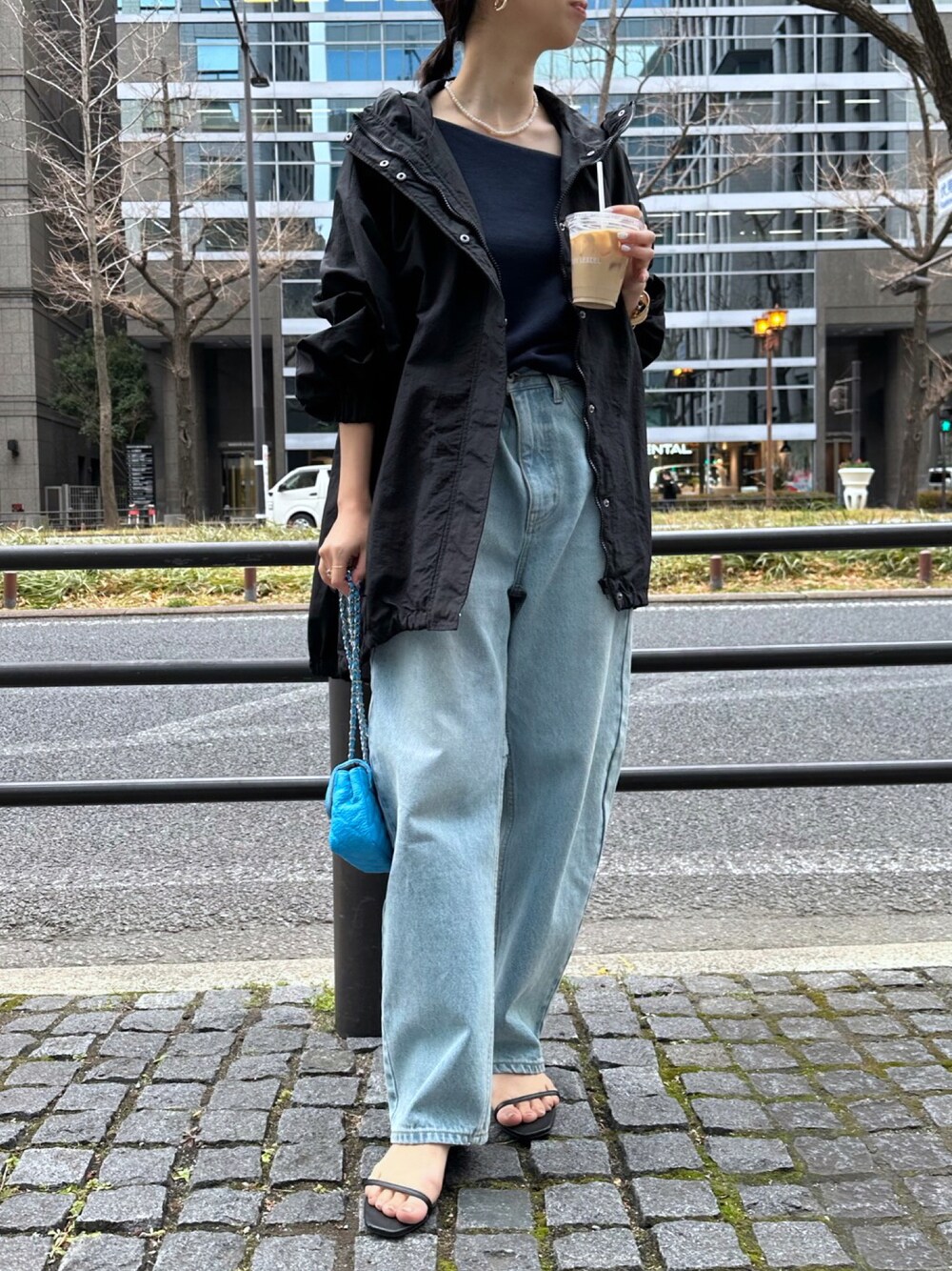 ブラック系のサンダル、ブルー系のデニムパンツ、ホワイト系のブルゾンを着用したレディースの冬コーディネートの1枚目の写真