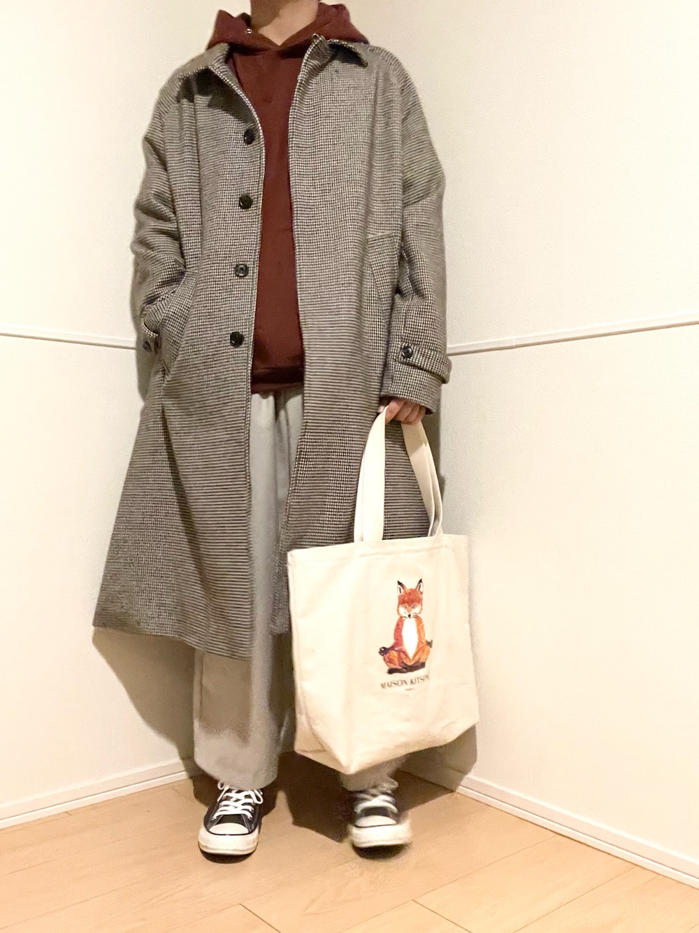 その他のステンカラーコート、ブラウン系のパーカー、ベージュ系のその他パンツを着用したメンズの春コーディネートの1枚目の写真