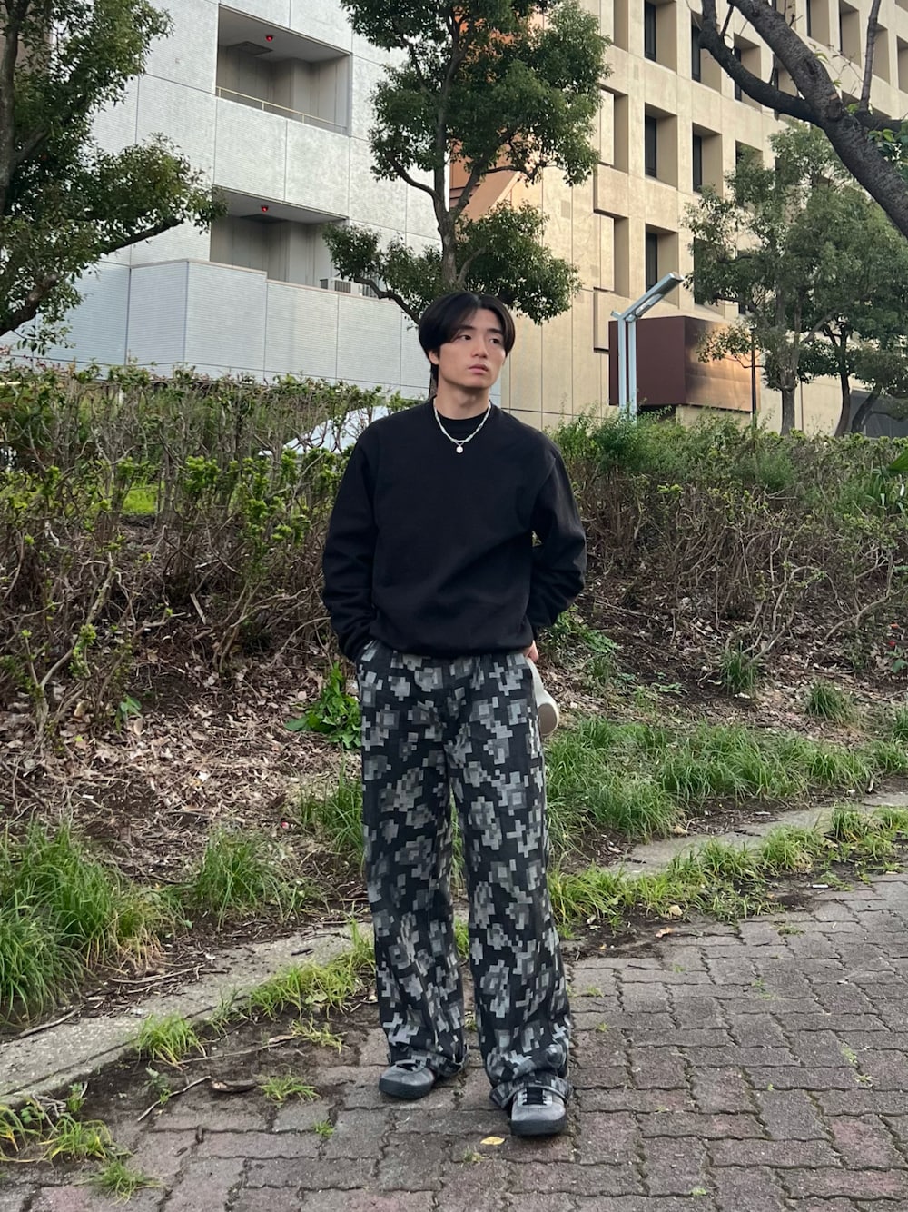 ブラック系のスウェット、ブラック系のチノパンツ、グレー系のスニーカーを着用したメンズの春コーディネートの1枚目の写真