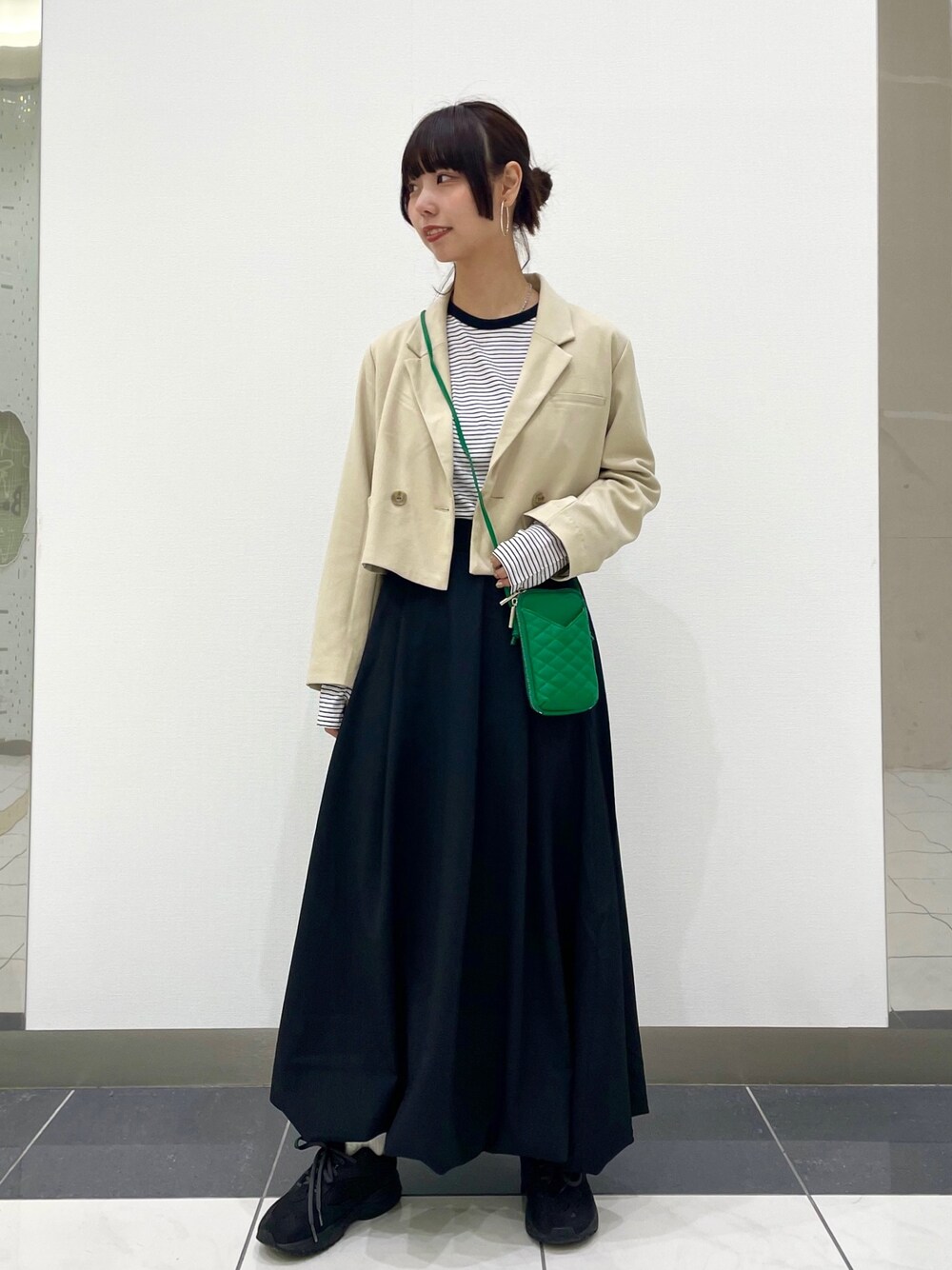 ベージュ系のその他アウター、ホワイト系のTシャツ/カットソー、ブラック系のスカートを着用したレディースの春コーディネートの1枚目の写真