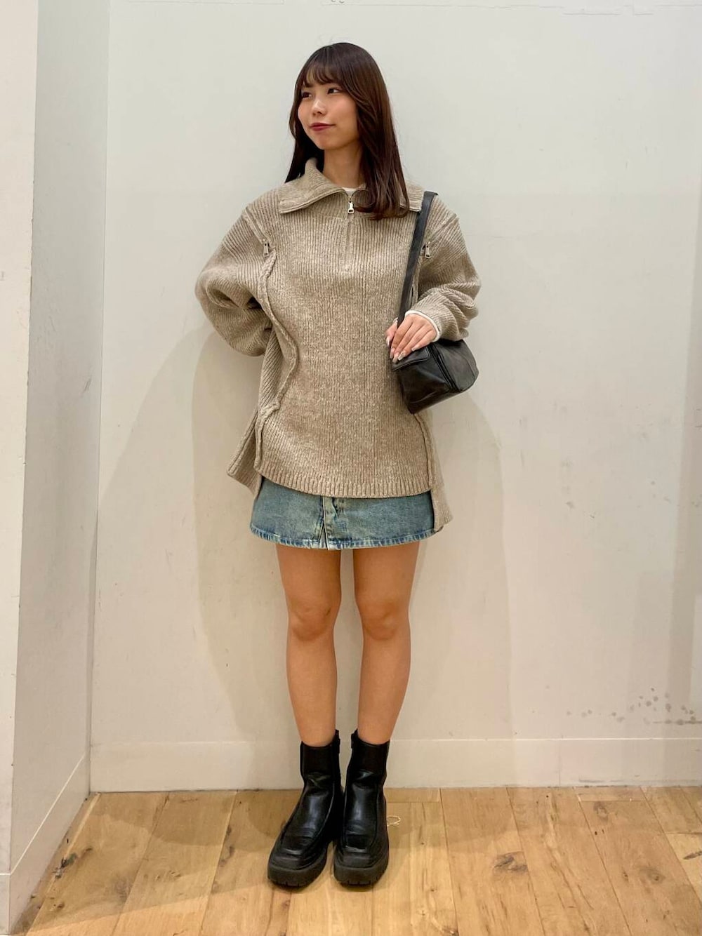 ベージュ系のニット/セーター、グレー系のハンドバッグ、ブルー系のスカートを着用したレディースの秋コーディネートの1枚目の写真