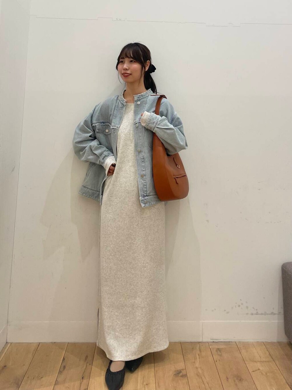 ブラウン系のショルダーバッグ、ブラック系のバレエシューズ、ベージュ系のワンピースを着用したレディースの冬コーディネートの1枚目の写真