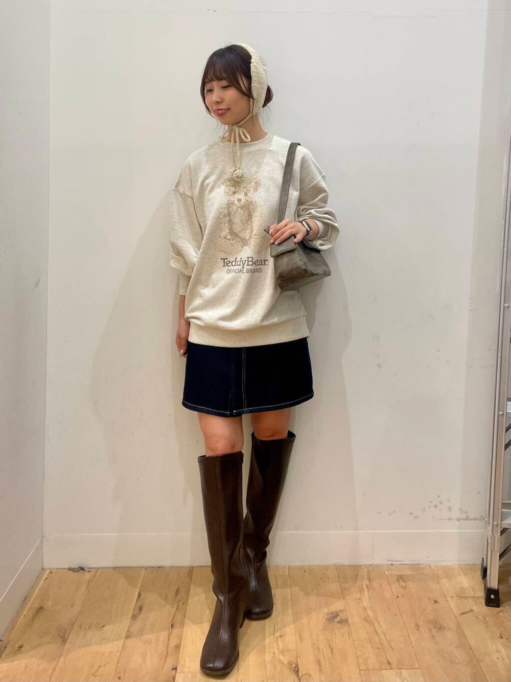 ブラウン系のブーツ、グレー系のハンドバッグ、ブルー系のスカートを着用したレディースの秋コーディネートの1枚目の写真