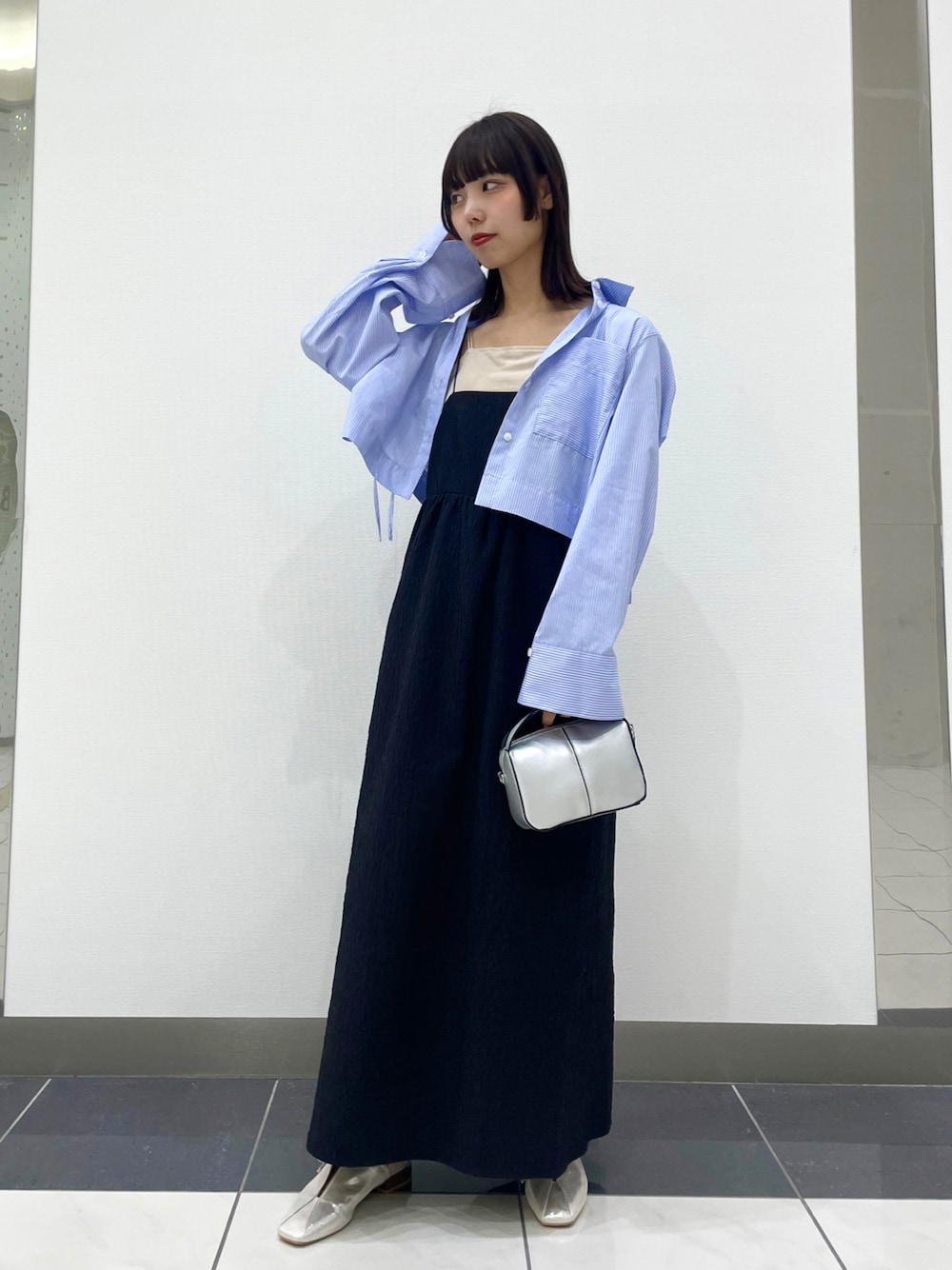 シルバー系のその他シューズ、ブルー系のシャツ/ブラウス、ブラック系のワンピースを着用したレディースの春コーディネートの1枚目の写真