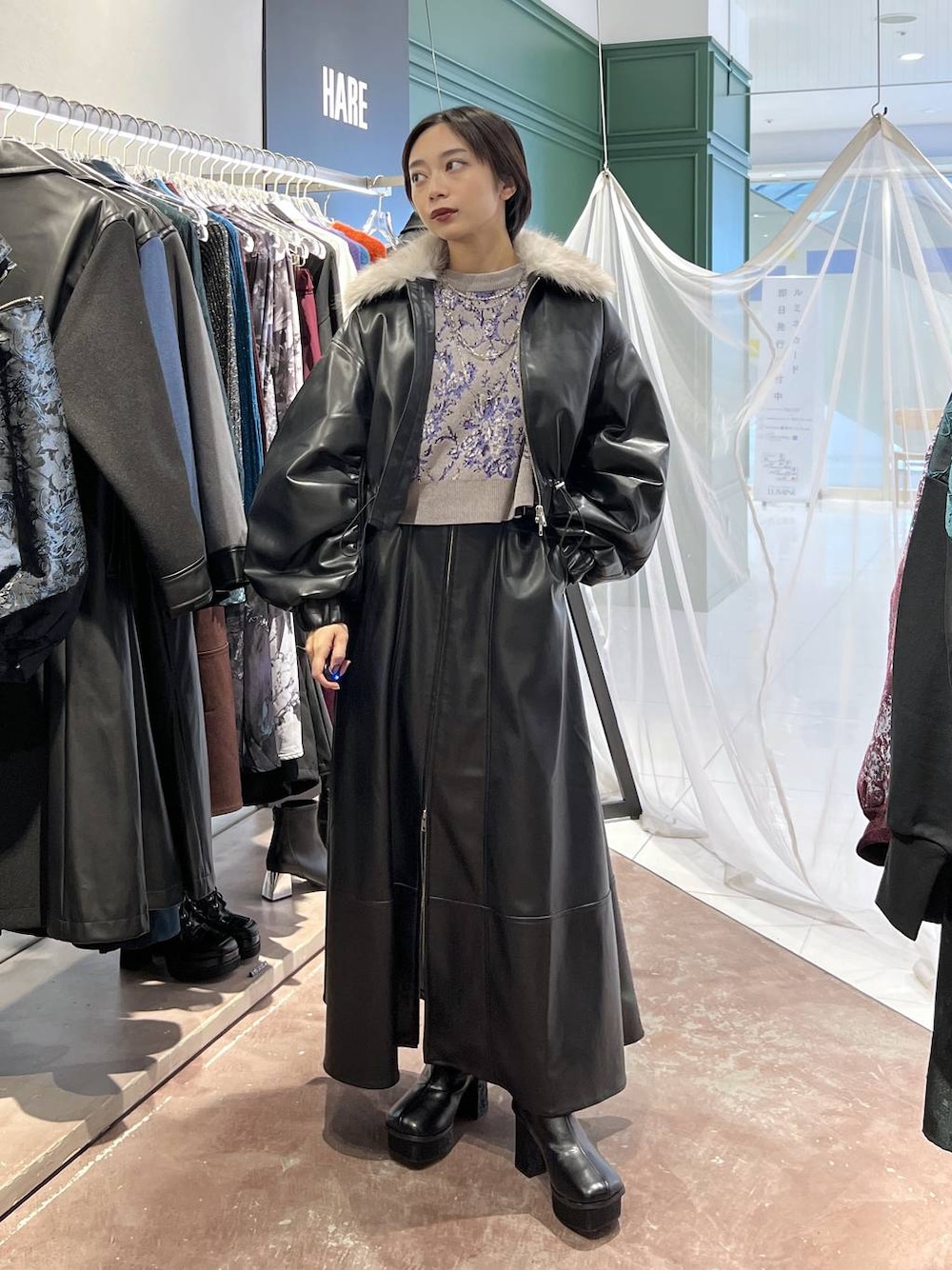 グレー系のニット/セーター、ブラック系のブーツ、ブラック系のブルゾンを着用したレディースの秋コーディネートの1枚目の写真