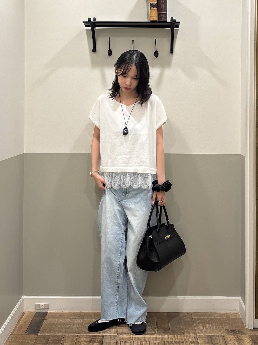 ブルー系のデニムパンツ、ブラック系のショルダーバッグ、ホワイト系のニット/セーターを着用したレディースの夏コーディネートの1枚目の写真