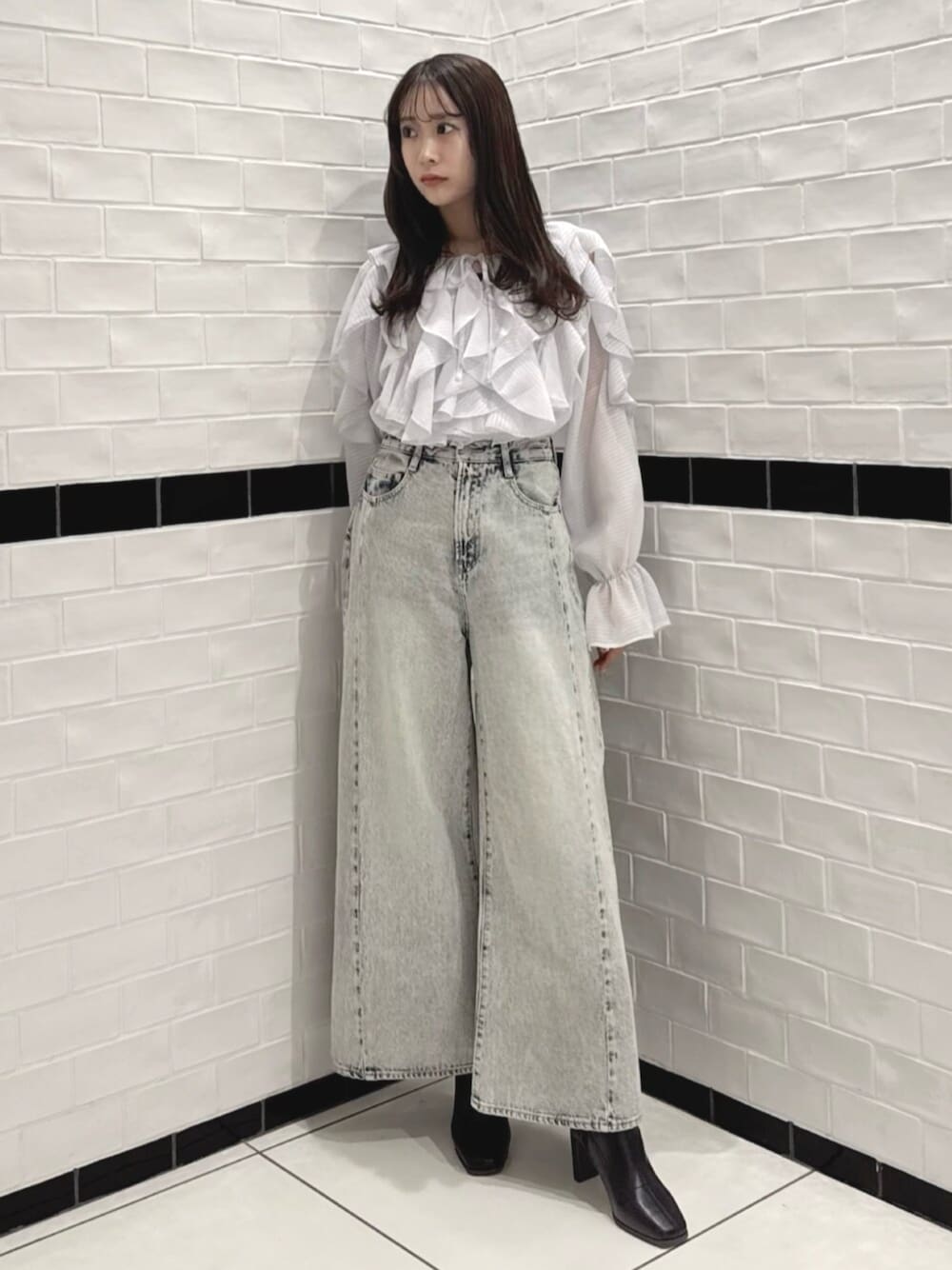 ブラック系のブーツ、グレー系のシャツ/ブラウス、ブルー系のデニムパンツを着用したレディースの春コーディネートの1枚目の写真