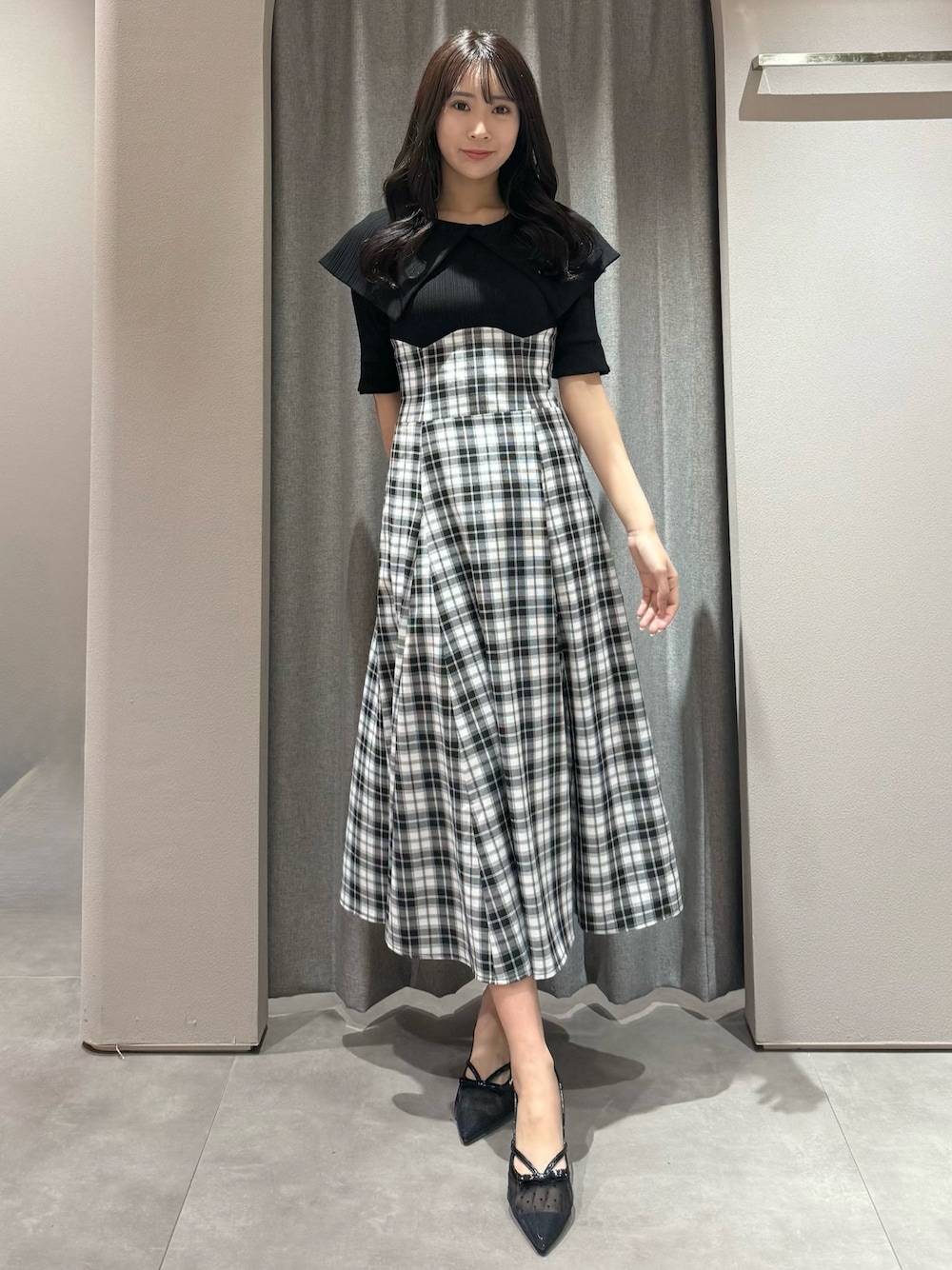 ブラック系のワンピース、ブラック系のパンプスを着用したレディースの春コーディネートの1枚目の写真