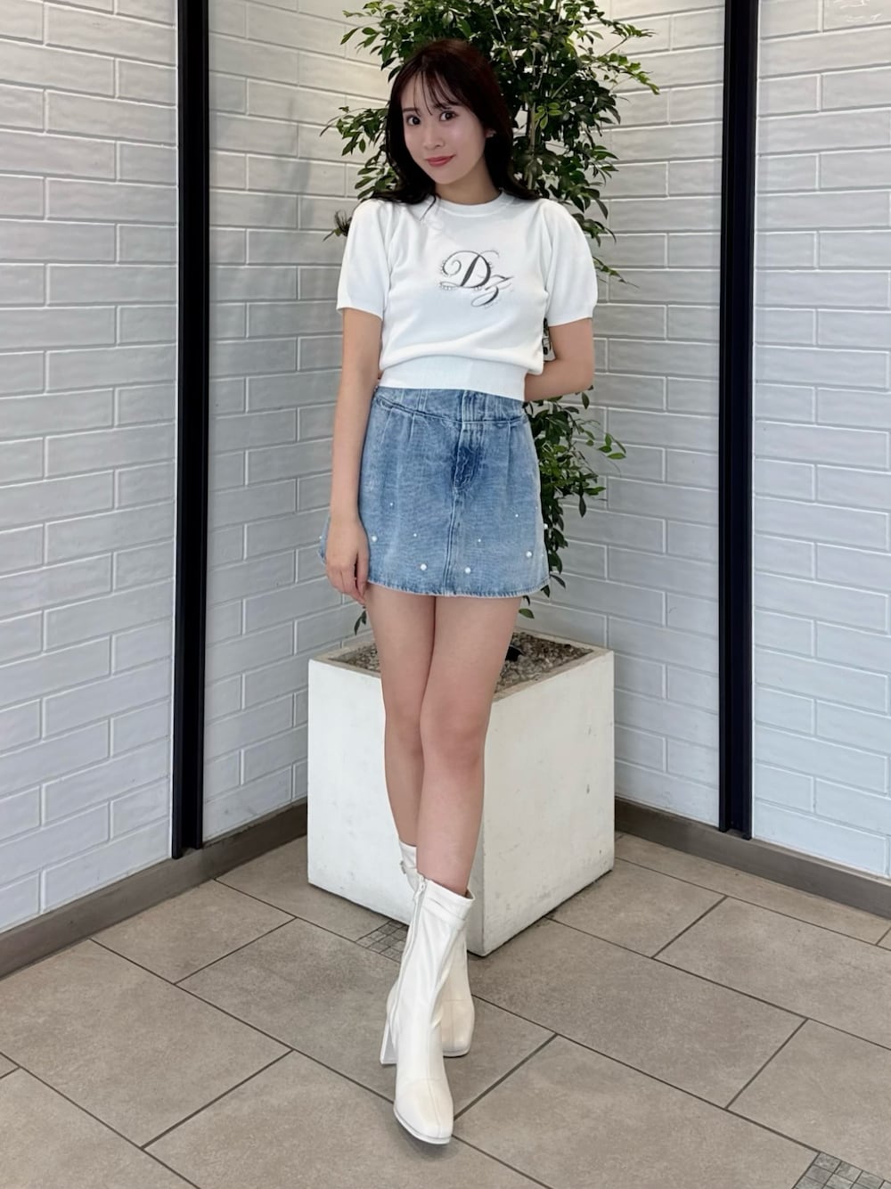 ホワイト系のニット/セーター、ブルー系のデニムパンツ、ホワイト系のブーツを着用したレディースの春コーディネートの1枚目の写真