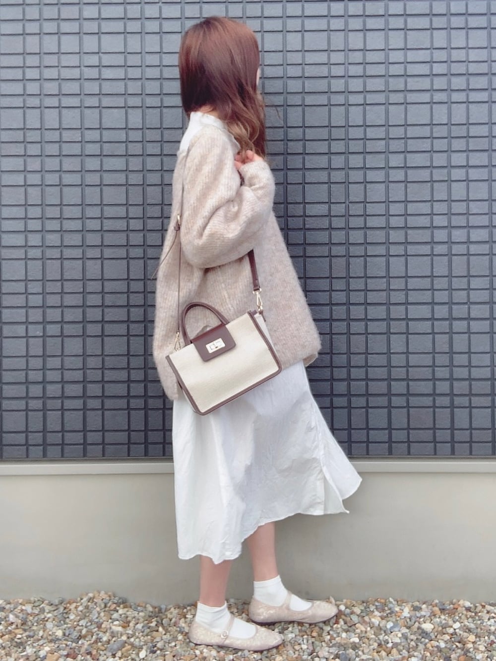 ホワイト系のシャツワンピース、ホワイト系のニット/セーター、ブラウン系のショルダーバッグを着用したレディースの冬コーディネートの1枚目の写真