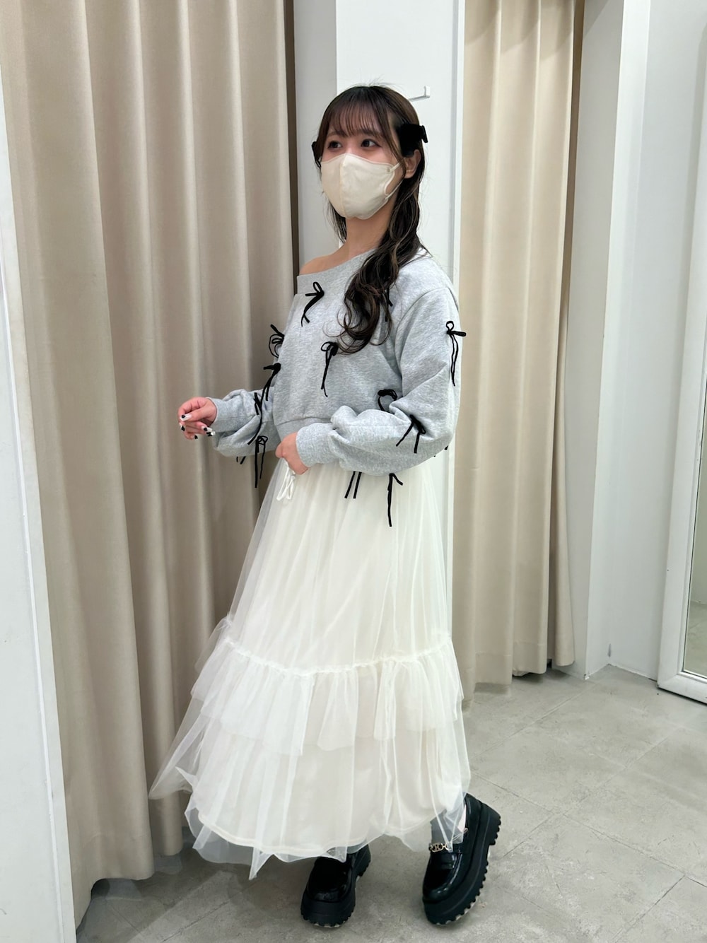 グレー系のスウェット、ホワイト系のスカート、ブラック系のローファーを着用したレディースの春コーディネートの1枚目の写真