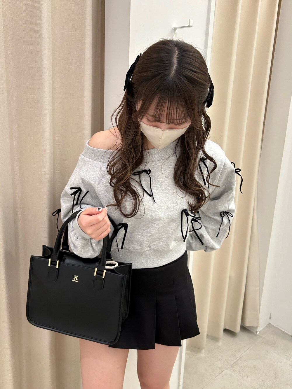 グレー系のスウェット、ブラック系のトートバッグ、ブラック系のスカートを着用したレディースの春コーディネートの1枚目の写真