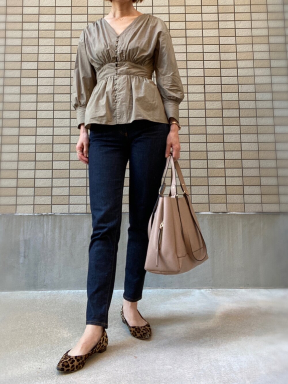 ベージュ系のシャツ/ブラウス、ブルー系のデニムパンツ、ベージュ系のトートバッグを着用したレディースの秋コーディネートの1枚目の写真