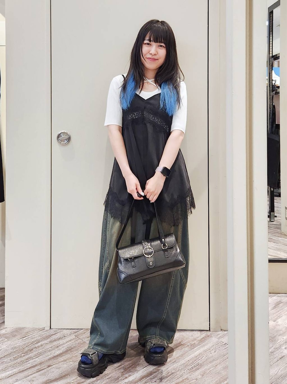 ブラック系のキャミソール、グリーン系のデニムパンツ、グレー系のサンダルを着用したレディースの秋コーディネートの1枚目の写真