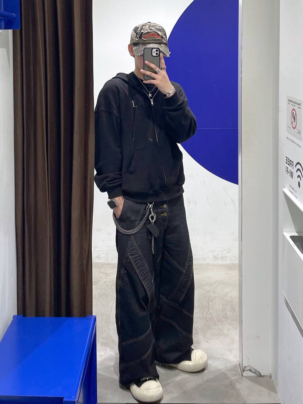 ブラック系のパーカー、ブラック系のデニムパンツ、ブラウン系のキャップを着用したメンズの秋コーディネートの1枚目の写真