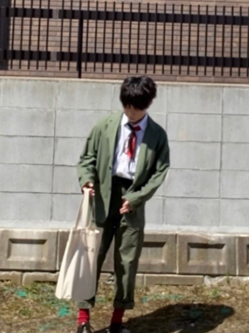 ベージュ系のトートバッグ、グリーン系のミリタリージャケット、グリーン系のカーゴパンツを着用したメンズの夏コーディネートの1枚目の写真