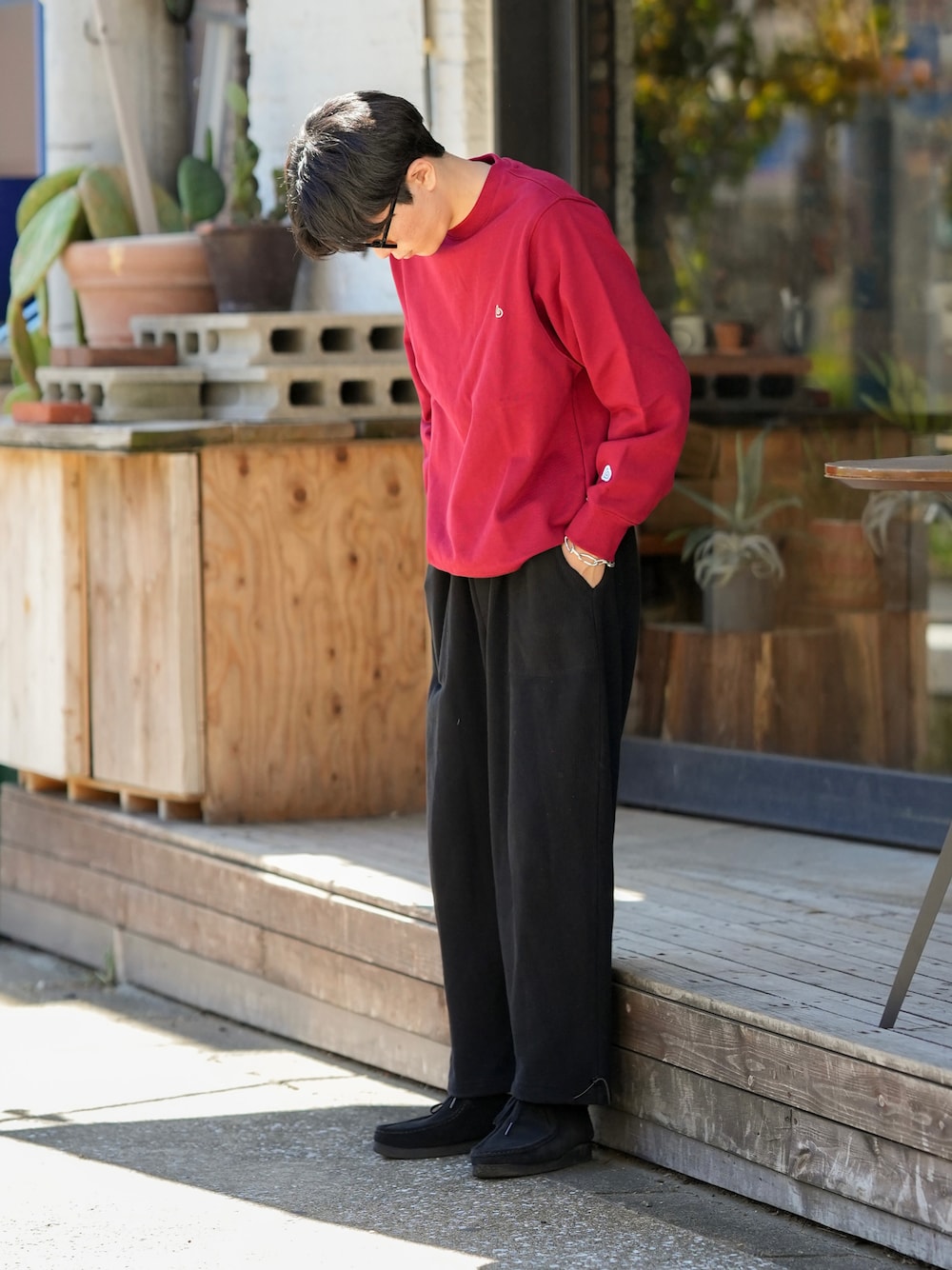 レッド系のスウェット、ブラック系のパンツ、ブラック系のモカシン/デッキシューズを着用したメンズの秋コーディネートの1枚目の写真