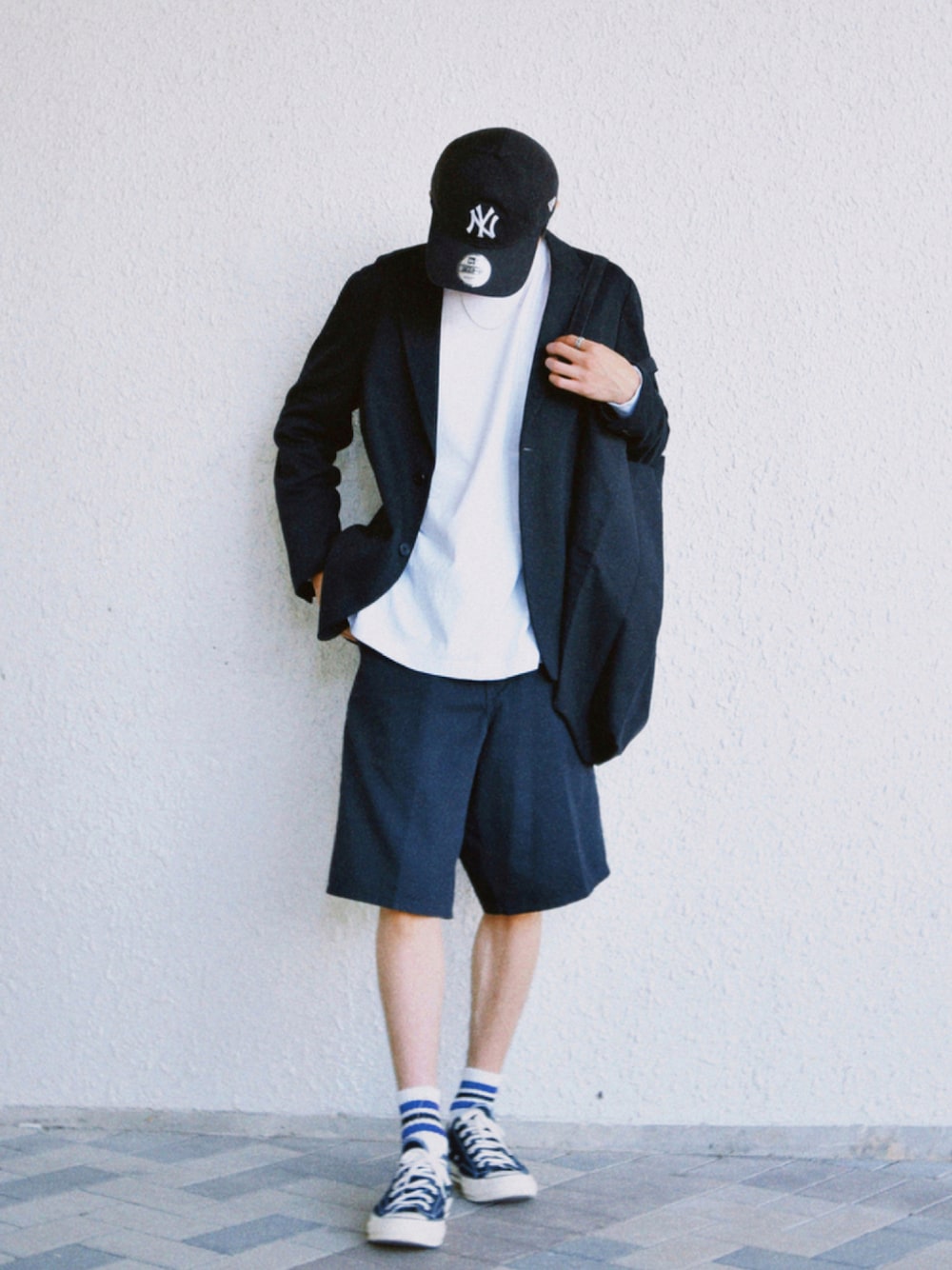 ブラック系のスニーカー、ブラック系のジャケット/アウター、ホワイト系のTシャツ/カットソーを着用したメンズの秋コーディネートの1枚目の写真