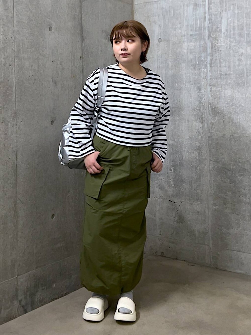 ホワイト系のサンダル、ブルー系のTシャツ/カットソー、シルバー系のバックパック/リュックを着用したレディースの春コーディネートの1枚目の写真