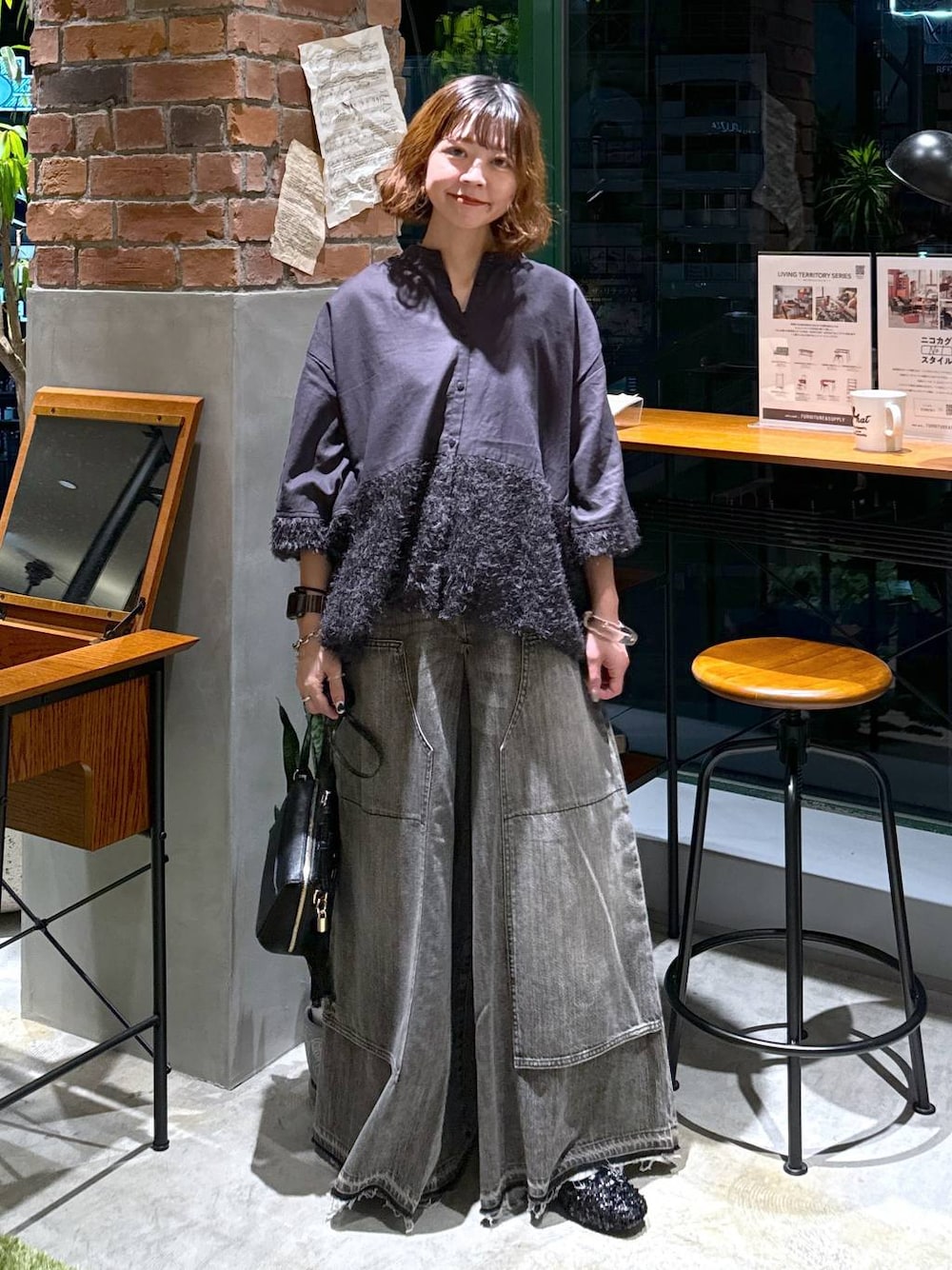 ブラック系のバレエシューズ、ブラック系のショルダーバッグ、ブラウン系のデニムパンツを着用したレディースの秋コーディネートの1枚目の写真