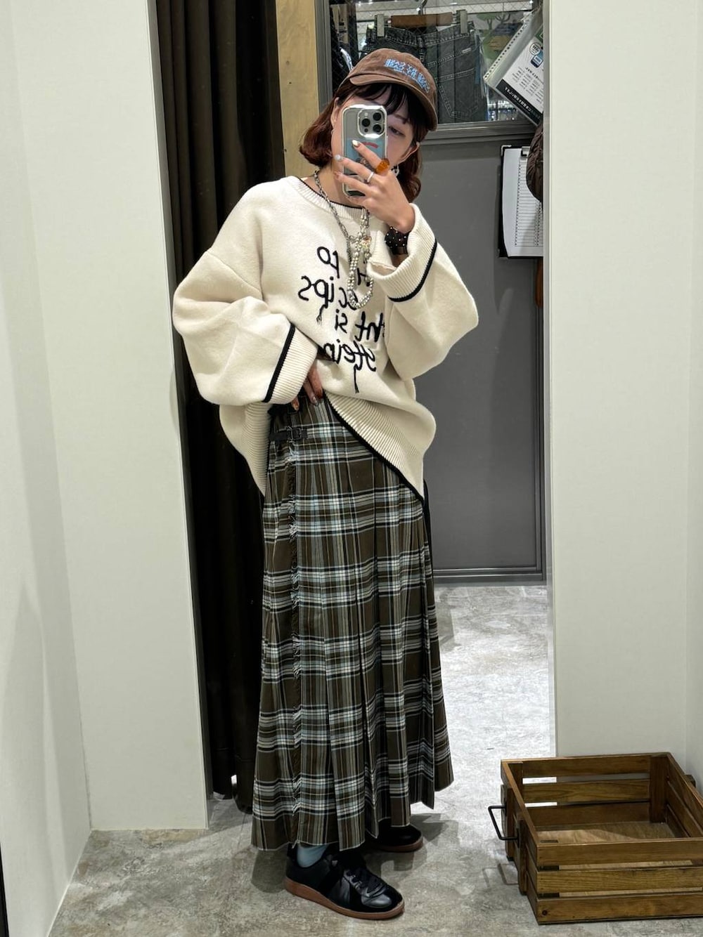 ブラウン系のスカート、ブラック系のスニーカー、ベージュ系のニット/セーターを着用したレディースの秋コーディネートの1枚目の写真