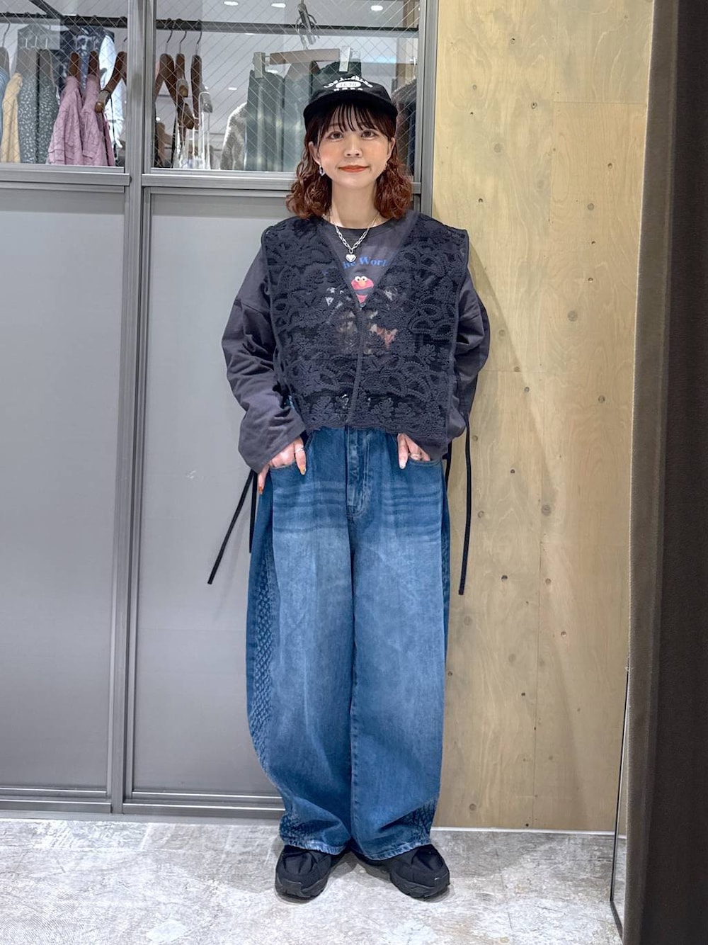 グレー系のTシャツ/カットソー、ブルー系のデニムパンツ、ブラック系のベストを着用したレディースの冬コーディネートの1枚目の写真