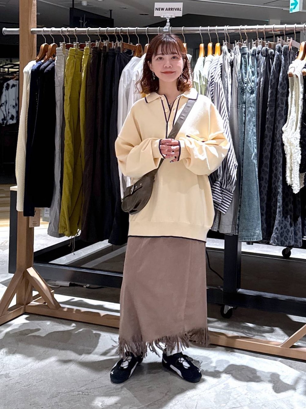 ブラウン系のショルダーバッグ、ブラウン系のスカートを着用したレディースの秋コーディネートの1枚目の写真