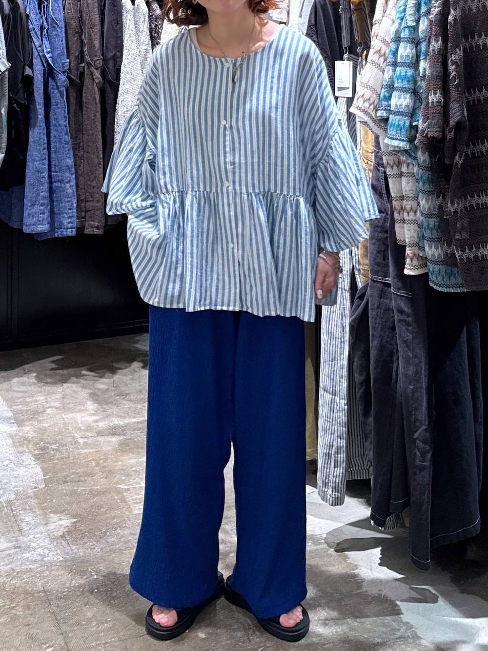 グレー系のタンクトップ、ブラック系のサンダル、ブルー系のその他パンツを着用したレディースの夏コーディネートの1枚目の写真