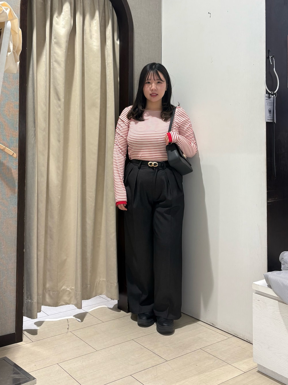 レッド系のTシャツ/カットソー、ブラック系のショルダーバッグ、ブラウン系のその他パンツを着用したレディースの春コーディネートの1枚目の写真