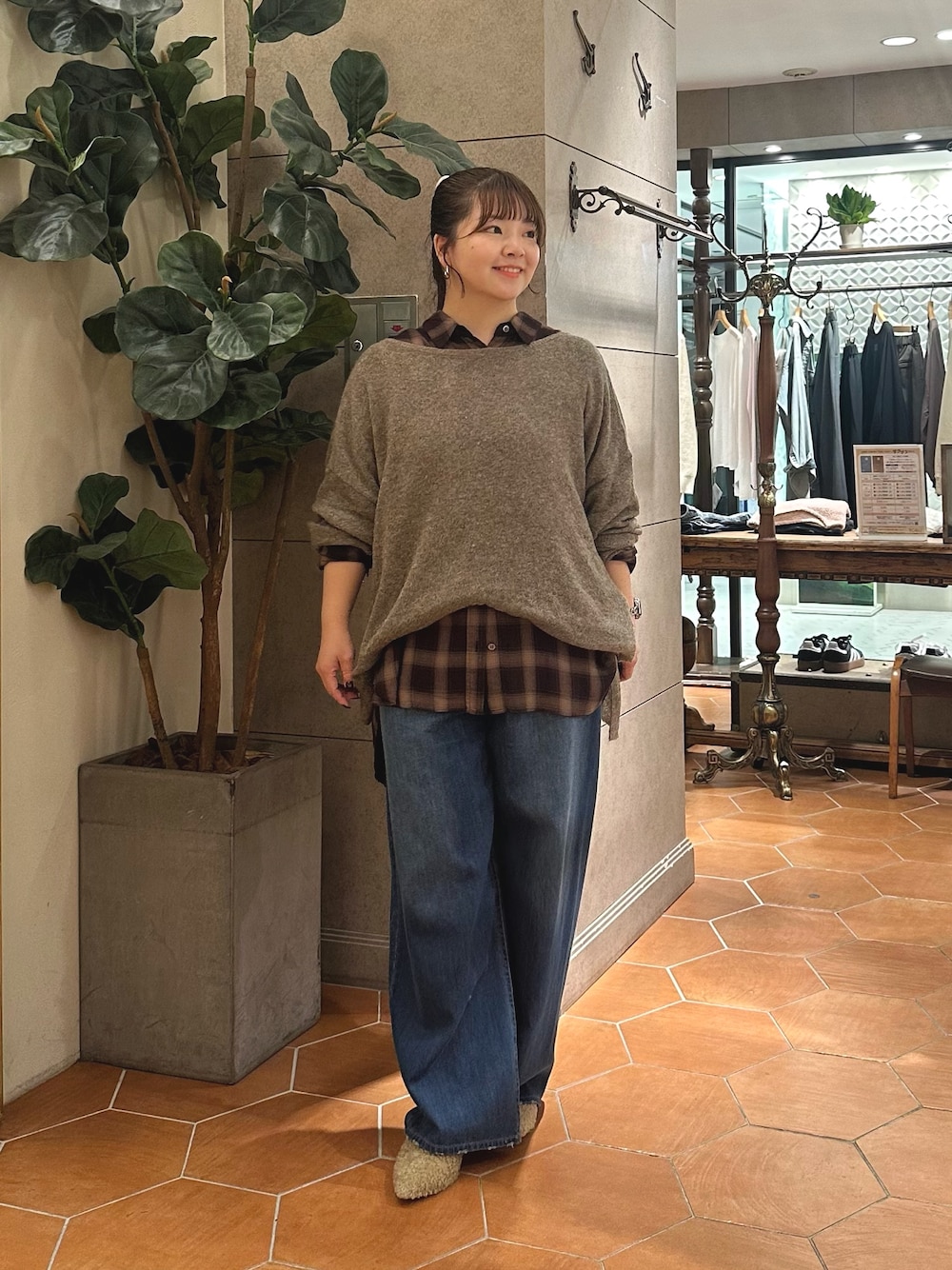 ベージュ系のシャツ/ブラウス、ブラウン系のニット/セーター、ブルー系のデニムパンツを着用したレディースの秋コーディネートの1枚目の写真