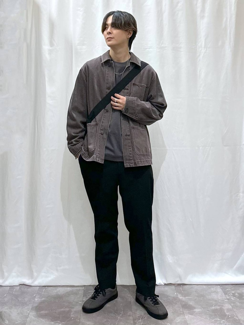 ブラウン系のTシャツ/カットソー、グレー系のスニーカー、ブラック系のスラックスを着用したメンズの秋コーディネートの1枚目の写真