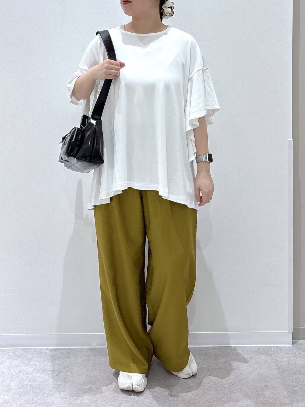 ブラック系のショルダーバッグ、ホワイト系のTシャツ/カットソーを着用したレディースの春コーディネートの1枚目の写真