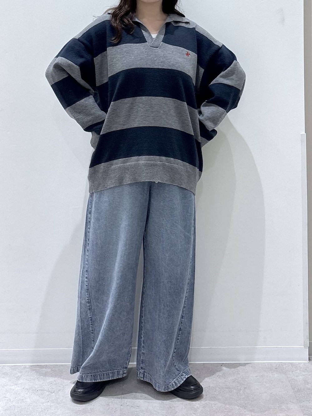 ブラック系のローファー、グレー系のニット/セーター、ブルー系のデニムパンツを着用したレディースの秋コーディネートの1枚目の写真