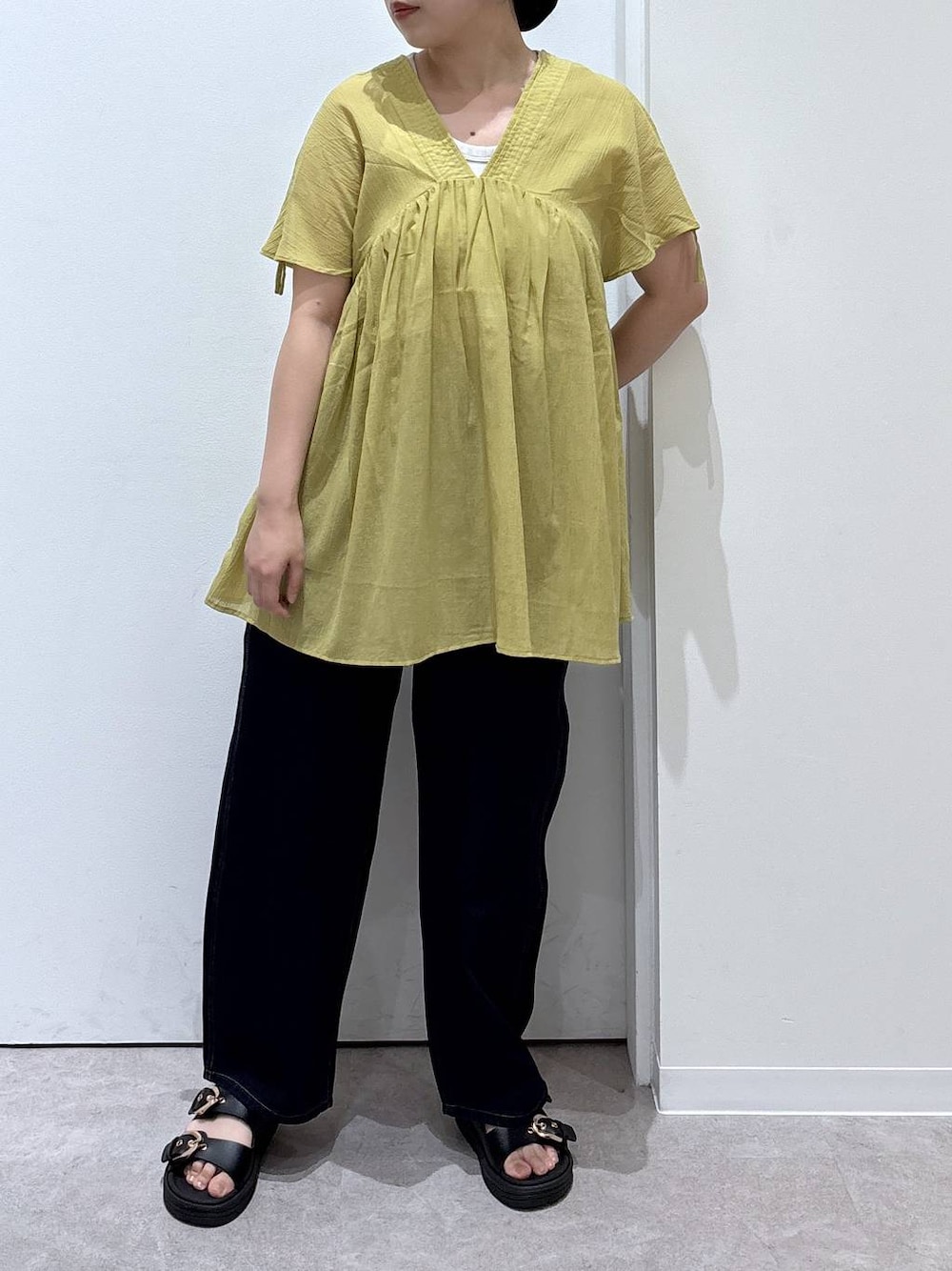 ブルー系のデニムパンツ、イエロー系のシャツ/ブラウス、ブラック系のサンダルを着用したレディースの夏コーディネートの1枚目の写真