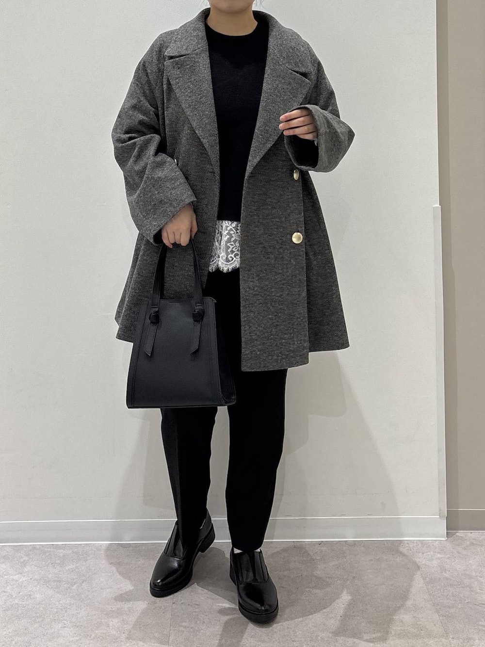 ブラック系のショルダーバッグ、グレー系のチェスターコート、ブラック系のその他パンツを着用したレディースの冬コーディネートの1枚目の写真