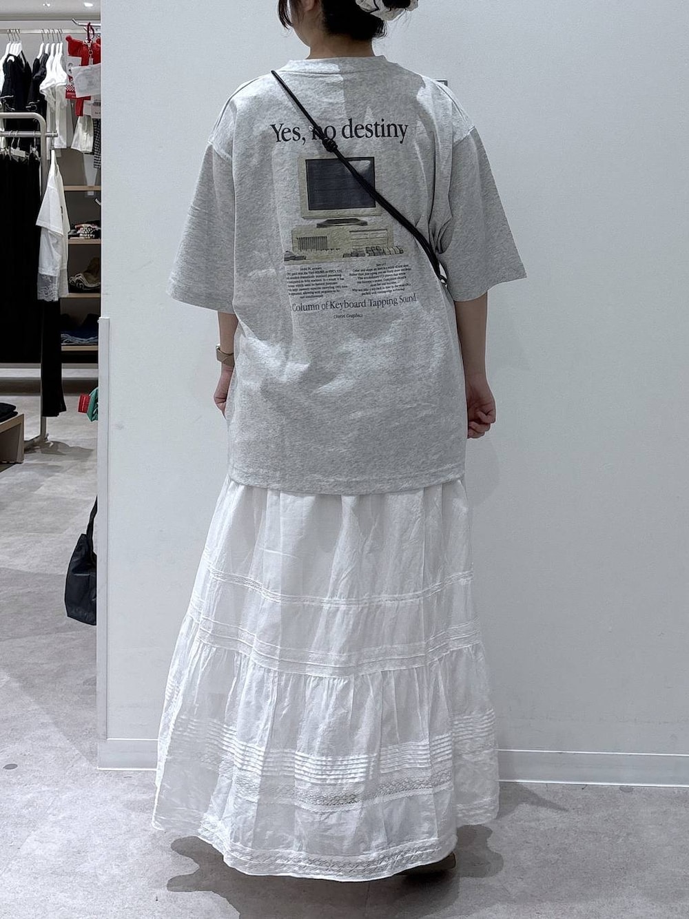 ホワイト系のスカート、グレー系のTシャツ/カットソー、ブラック系のスマホグッズを着用したレディースの夏コーディネートの1枚目の写真