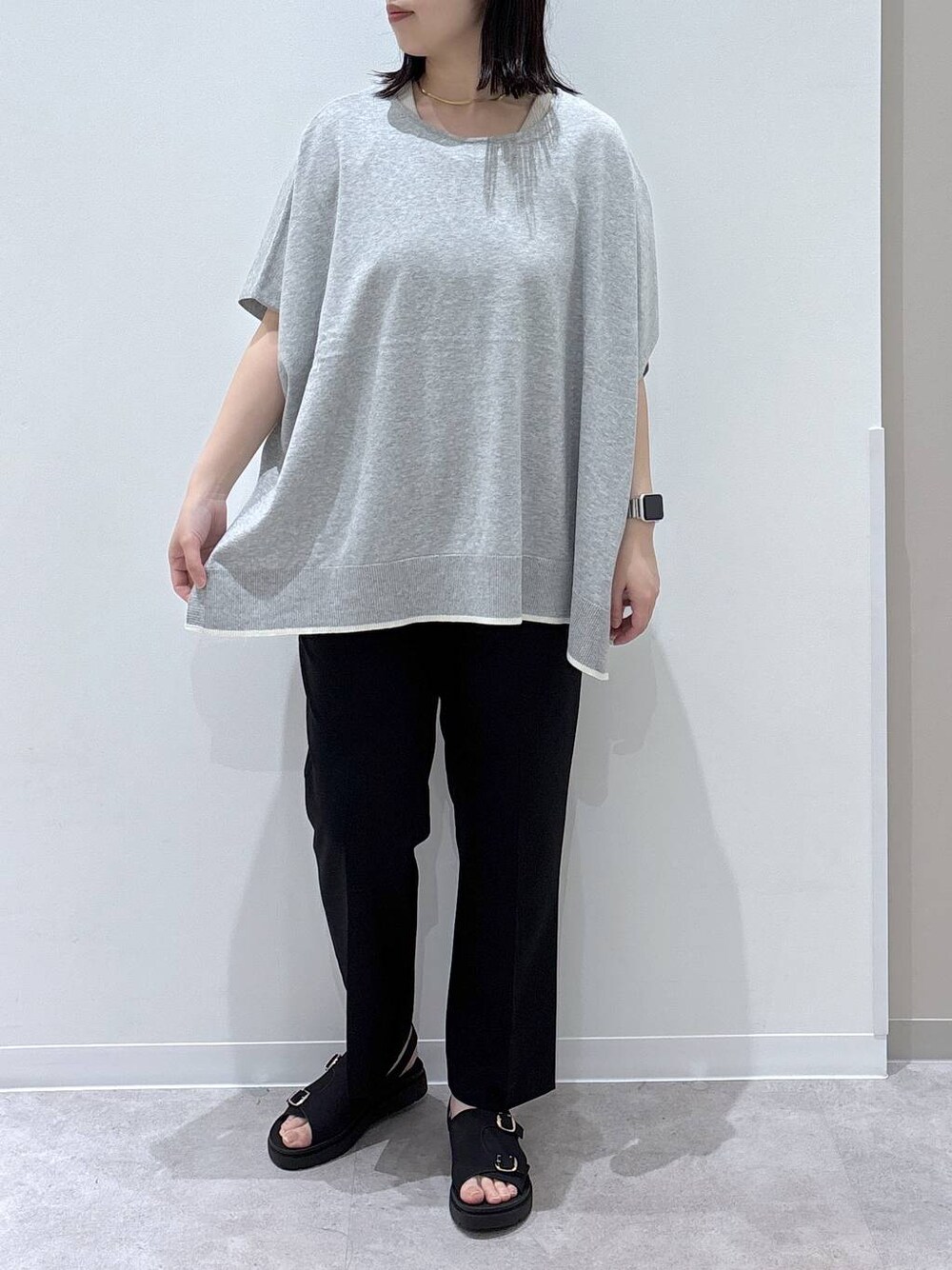 グレー系のニット/セーター、ブラック系のその他パンツ、ブラック系のサンダルを着用したレディースの春コーディネートの1枚目の写真