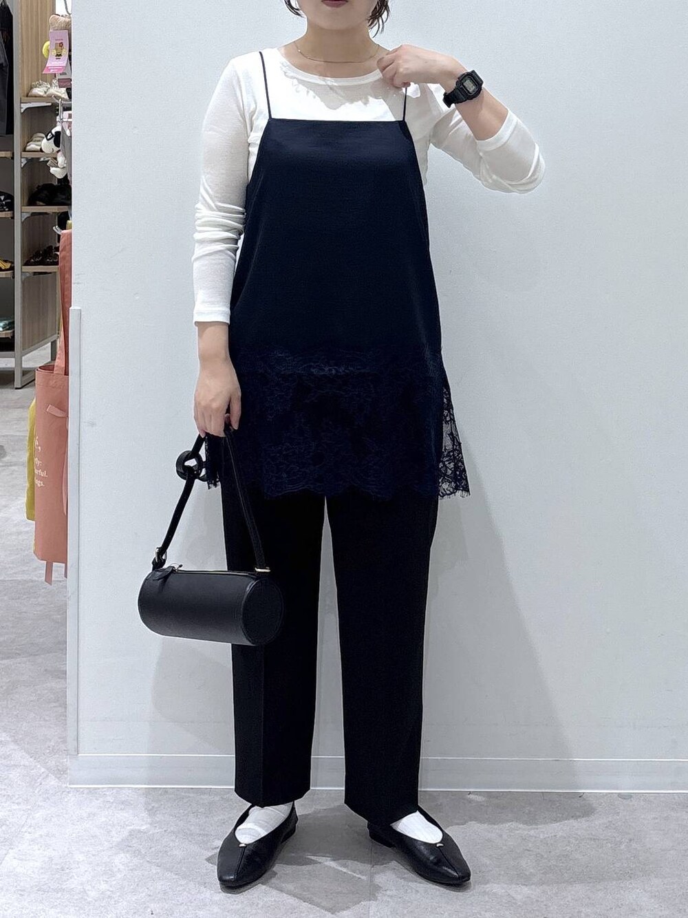 ブラック系のパンプス、ブラック系のクラッチバッグ、ホワイト系のTシャツ/カットソーを着用したレディースの秋コーディネートの1枚目の写真