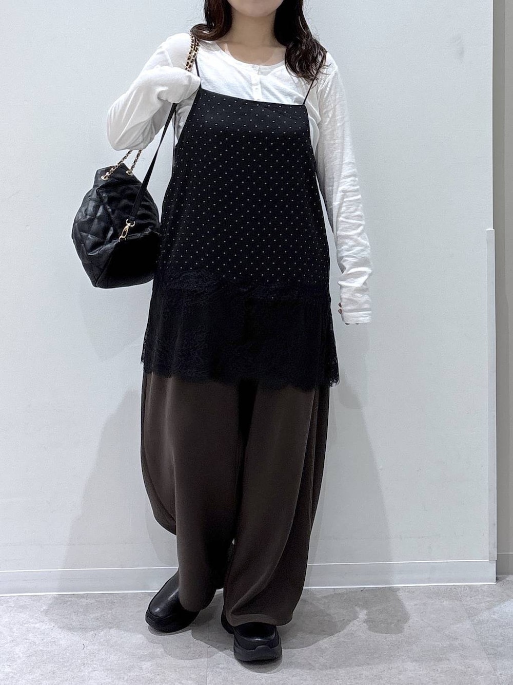 ホワイト系のTシャツ/カットソー、ブラック系のトートバッグ、ブラック系のブーツを着用したレディースの秋コーディネートの1枚目の写真