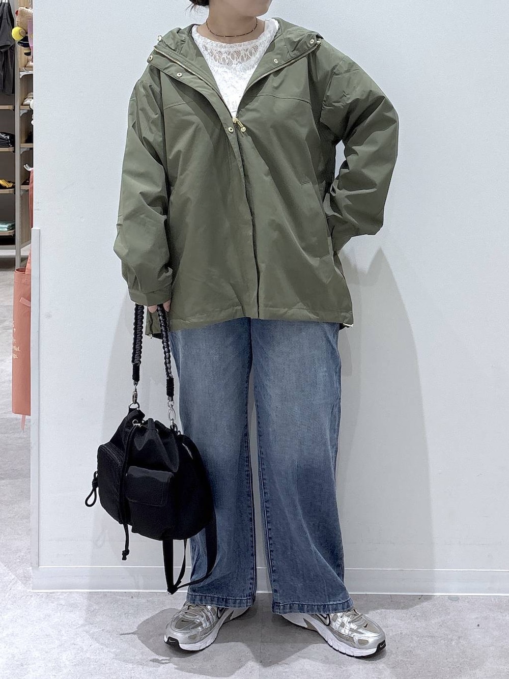 ブルー系のデニムパンツ、ホワイト系のTシャツ/カットソー、グリーン系のマウンテンパーカーを着用したレディースの秋コーディネートの1枚目の写真