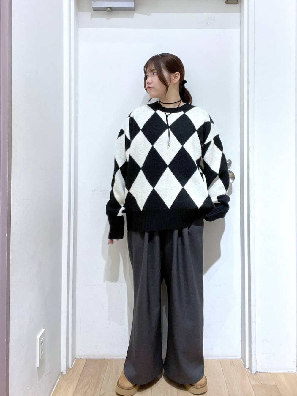 グレー系のその他パンツ、ブラック系のニット/セーター、ベージュ系のブーツを着用したレディースの秋コーディネートの1枚目の写真