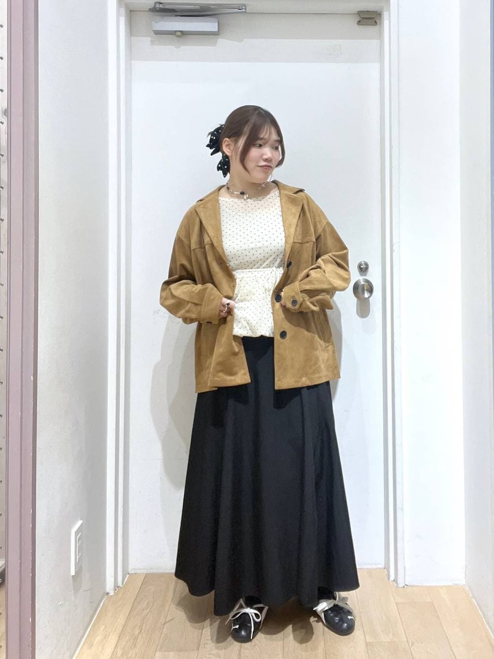 ブラウン系のテーラードジャケット、ホワイト系のTシャツ/カットソー、ブラック系のスカートを着用したレディースの冬コーディネートの1枚目の写真