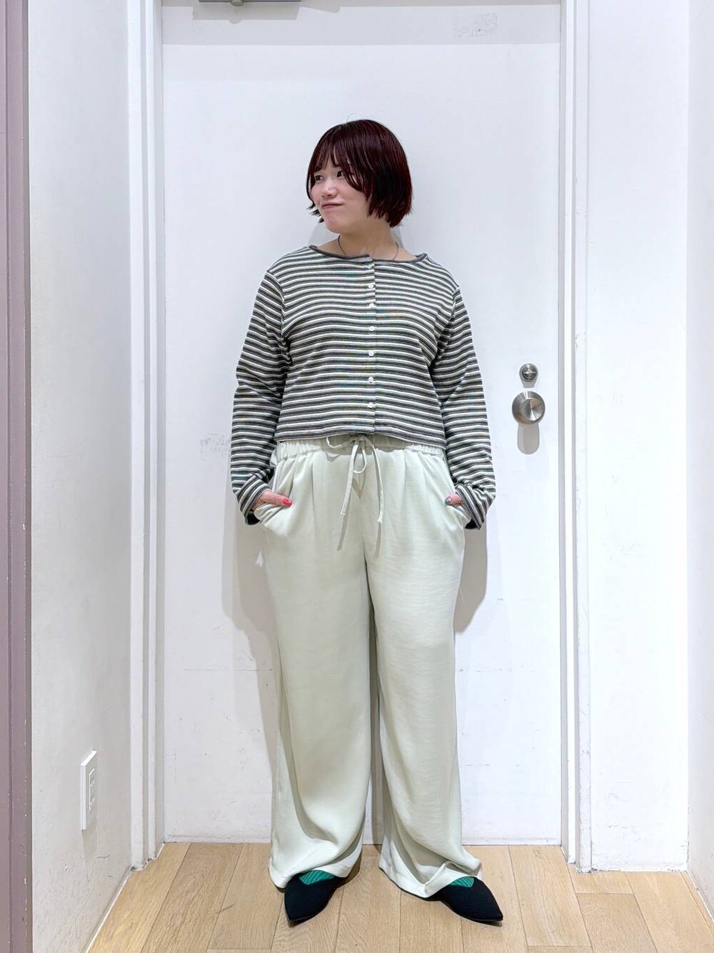ブラック系のパンプス、グリーン系のその他パンツ、グレー系のカーディガン/ボレロを着用したレディースの春コーディネートの1枚目の写真