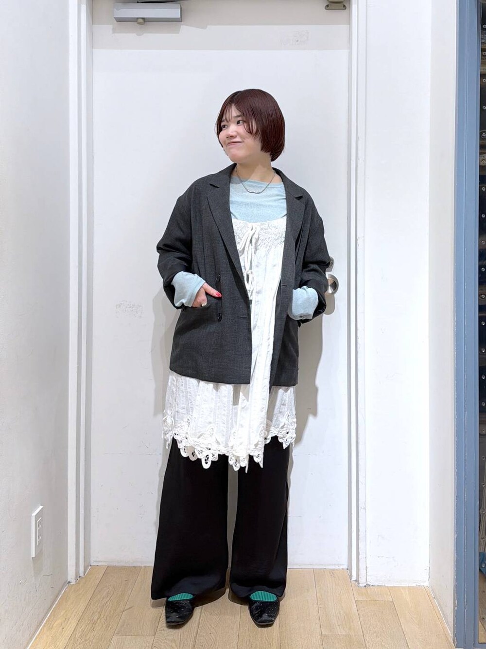 グレー系のテーラードジャケット、ブラック系のその他パンツ、ホワイト系のワンピースを着用したレディースの春コーディネートの1枚目の写真