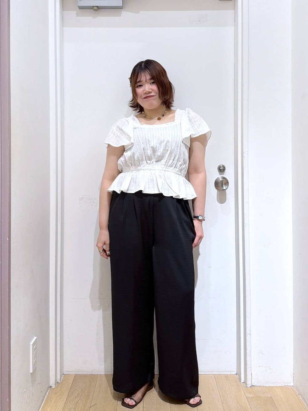 ブラック系のその他パンツ、ブラウン系のサンダル、ホワイト系のシャツ/ブラウスを着用したレディースの夏コーディネートの1枚目の写真
