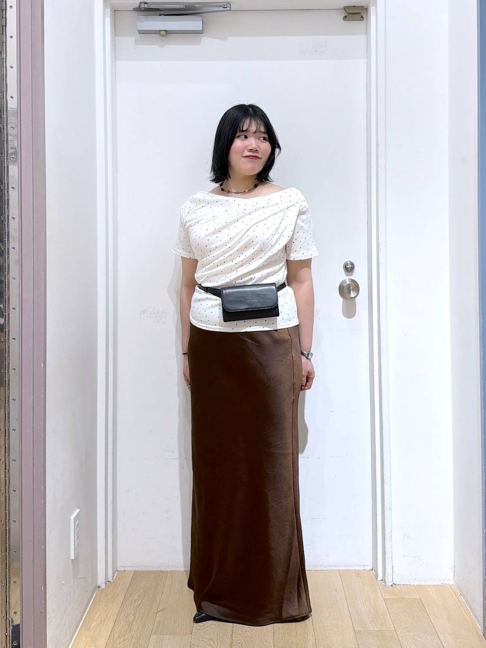 ベージュ系のTシャツ/カットソー、ブラウン系のスカート、ブラック系のボディバッグ/ウエストポーチを着用したレディースの夏コーディネートの1枚目の写真
