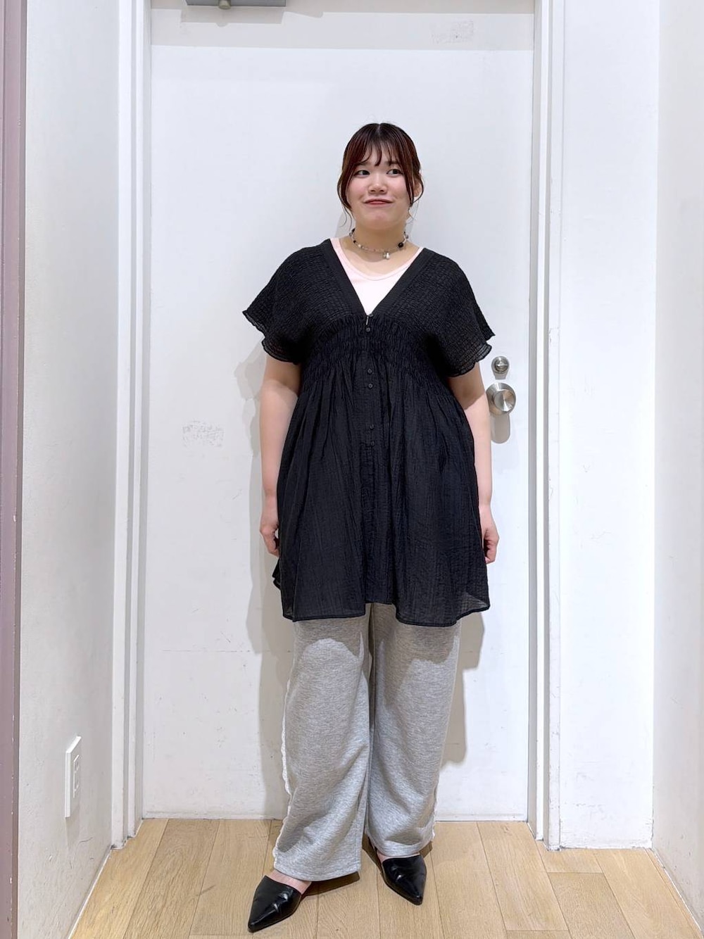 グレー系のスウェットパンツ、ブラック系のシャツ/ブラウス、ブラック系のサンダルを着用したレディースの春コーディネートの1枚目の写真