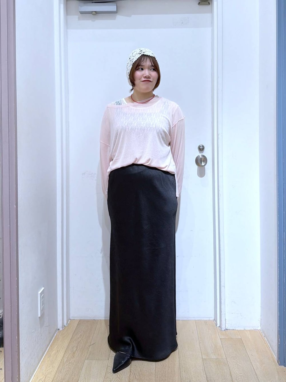 ブラック系のスカート、ピンク系のTシャツ/カットソー、ブラック系のサンダルを着用したレディースの春コーディネートの1枚目の写真