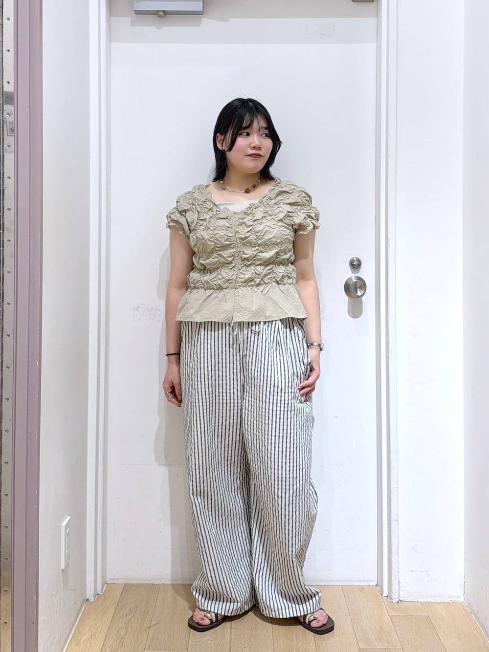 ベージュ系のシャツ/ブラウス、シルバー系のタンクトップ、ブラウン系のサンダルを着用したレディースの夏コーディネートの1枚目の写真